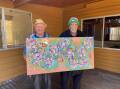Kinchela Boys Home survivors (L-R) Uncle James Michael 'Widdy' Welsh and Uncle Richard Campbell hold an artwork created by Uncle Richard for the 100th Anniversary. Picture by Ellie Chamberlain